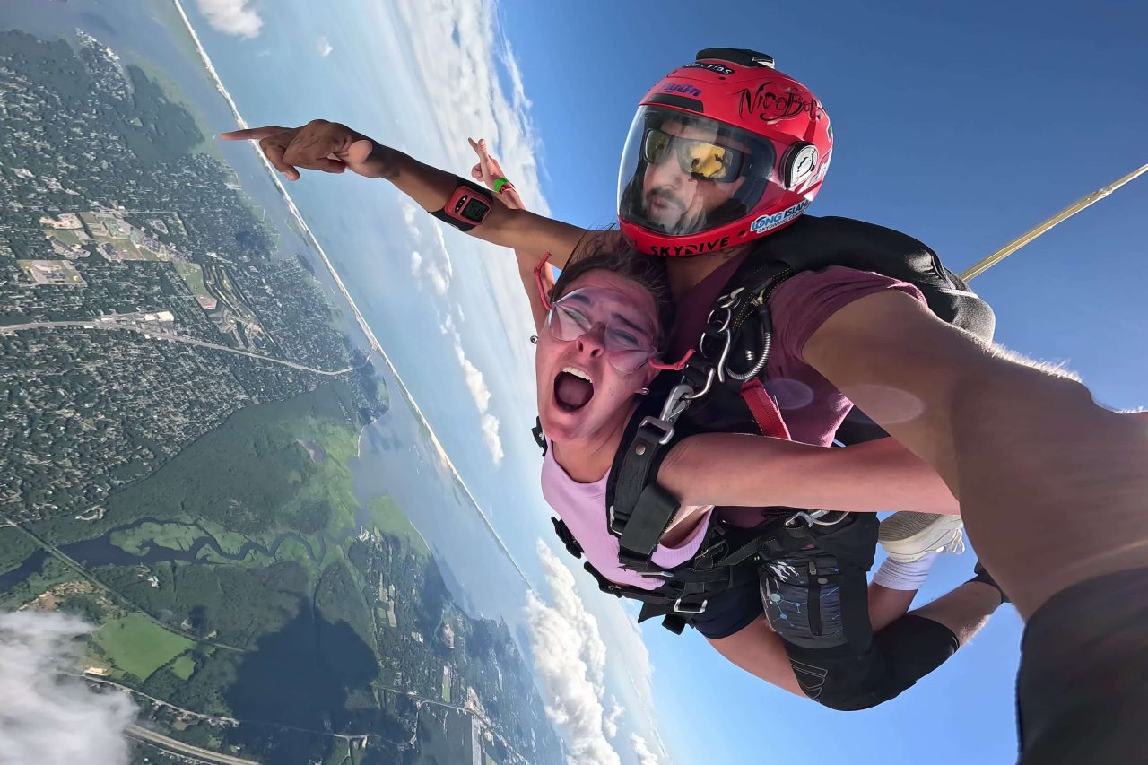 Thrilled girl skydiving by the New York coastline